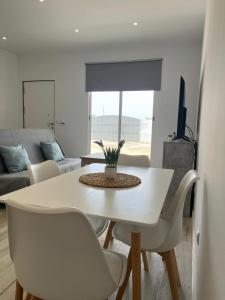 a white dining table and chairs in a living room at El Rinconcito de la Jara con Parking para varios coches in Sanlúcar de Barrameda