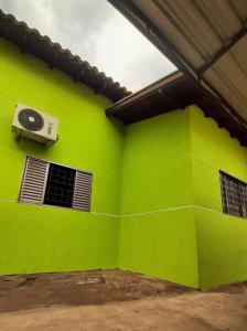 a green wall with an air conditioner on a building at Casa ampla central in Dourados +3 photos