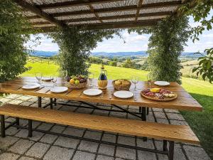a wooden table with baskets of fruit and wine glasses at Apartment Siena by Interhome in Vergelle