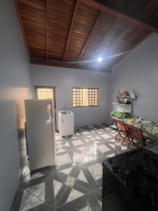a kitchen with a refrigerator and a table in it at Casa ampla central in Dourados