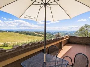 a table with an umbrella on a balcony at Apartment Torrenieri by Interhome in Vergelle