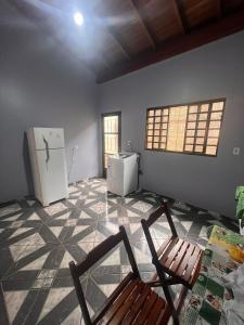 a kitchen with a refrigerator and two chairs in a room at Casa ampla central in Dourados