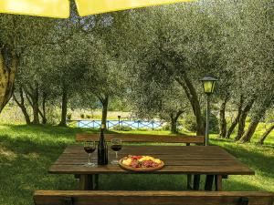 a picnic table with a plate of food and wine glasses at Apartment Monteroni by Interhome in Vergelle
