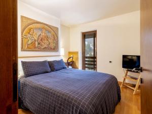 a bedroom with a bed and a painting on the wall at Apartment La Marmotta by Interhome in Madesimo