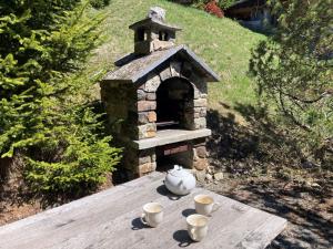 a stone oven with cups on a wooden table at Chalet Veni- Vidi- Mansi by Interhome in Champex