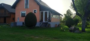a house with a porch and a door in the yard at Holiday Home Vuković Plitvice Mountain Retreat in Saborsko