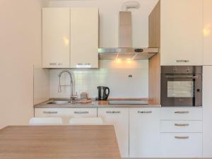 a kitchen with white cabinets and a wooden counter top at Apartment Sole e Fiori by Interhome in Domaso