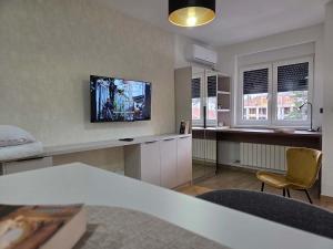 a living room with a tv on a wall at Apartmani Optimist in Valjevo