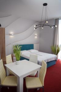 a room with a table and chairs and a bed at Aquila Hotel in Zator