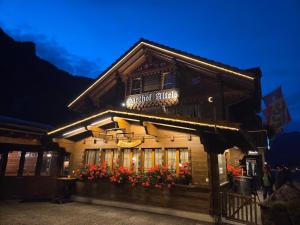 a building with flowers in front of it at night at Hotel Altels in Kandergrund