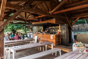 a restaurant with wooden tables and a bar at Vila Háj in Úsov