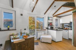 a kitchen with white cabinets and a table with fruit on it at La Chicchetta - Happy Rentals in Sauze d'Oulx