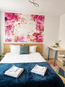 a bedroom with a bed with two towels on it at NATURA Garden in Cluj-Napoca