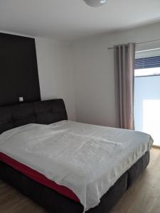 a bedroom with a large bed with a window at Bungalow HWW am Feldrand Ideal für Feriengäste und Handwerker in Wentorf