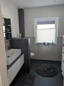 a bathroom with a sink and a toilet and a window at Bungalow HWW am Feldrand Ideal für Feriengäste und Handwerker in Wentorf +7 photos