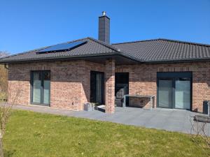a brick house with a patio in front of it at Bungalow HWW am Feldrand Ideal für Feriengäste und Handwerker in Wentorf
