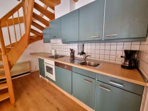 a kitchen with blue cabinets and a sink at Haus 11 Außergewöhnlich schön gelegen Natur Ferienpark im Teutoburger Wald in Nieheim