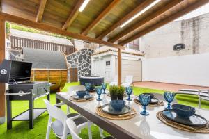 a patio with a table and chairs and a grill at Eden Rentals Villa Marysol in Sauzal
