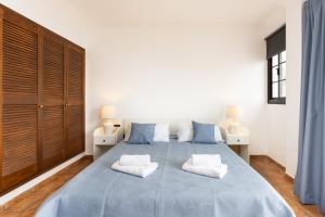 a bedroom with a large blue bed with two white pillows at Eden Rentals Villa Marysol in Sauzal