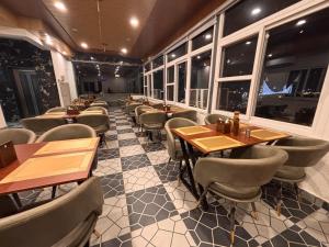 a restaurant with wooden tables and chairs and windows at Hotel shivay palace in Rishīkesh