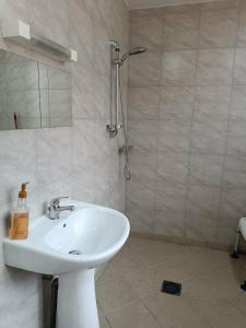 ein Badezimmer mit weißem Waschbecken und Dusche in der Unterkunft Hotel du Centre in Châlus + 13 Fotos