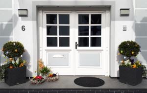 a white door on a house with flowers in baskets at Ferienhaus Binz in Binz