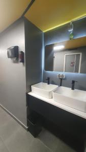 a bathroom with two sinks and a mirror at Yellow Monkey Hostel Uluwatu in Uluwatu +12 photos
