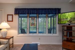 a living room with a large window with blue curtains at Home Away From Home · Home-Away-From-Home in Rosman