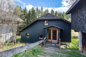 a blue house with a wooden door in a yard at Chalet 22 Bernau in Bernau im Schwarzwald