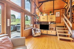 a living room with a tv and a staircase at Chalet 22 Bernau in Bernau im Schwarzwald