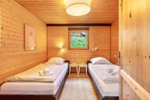 a room with two beds in a wooden cabin at Chalet 22 Bernau in Bernau im Schwarzwald
