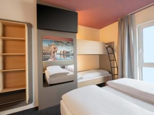 a room with two beds and a bunk bed at B&B HOTEL Stralsund in Stralsund