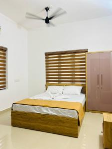 a bedroom with a bed with a ceiling fan at Easy Nest Kannur in Valapattanam