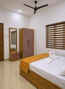 a bedroom with a bed with a towel on it at Easy Nest Kannur in Valapattanam