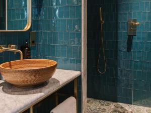 a bathroom with blue tiled walls and a sink at The Dean Galway in Galway