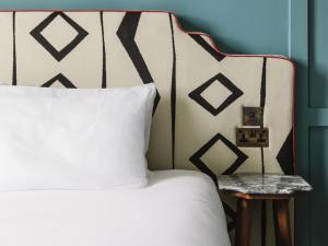 a bed with a white pillow and a side table at The Dean Galway in Galway +79 photos