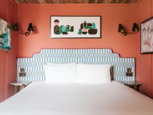a bedroom with a white bed and orange walls at The Dean Galway in Galway