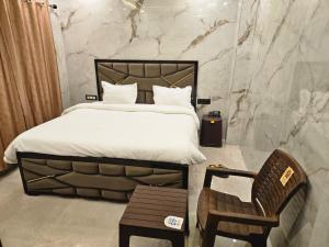 a bedroom with a large bed and a chair at Royal Guest House in Jammu