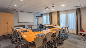 a classroom with tables and chairs and a projection screen at Campanile NATURE - Bayonne in Bayonne