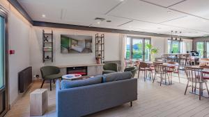 a living room with a couch and chairs and tables at Campanile NATURE - Bayonne in Bayonne