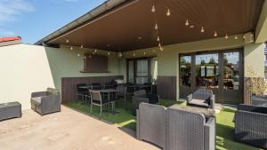 an outdoor patio with chairs and tables and a bar at Campanile NATURE - Bayonne in Bayonne