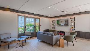 a living room with a couch and chairs at Campanile NATURE - Bayonne in Bayonne