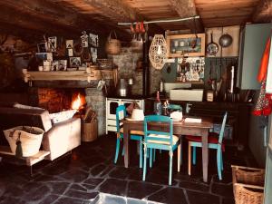 a dining room with a table and chairs and a fireplace at VeNeZ DoRmiR dans notre Bergerie au Cœur des Pyrénées Hebergement atypique in Bordères-Louron