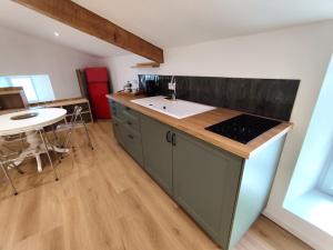 a kitchen with a sink and a counter with a table at Gîte Calme - Vue sur Garonne - Parking privé in Baurech