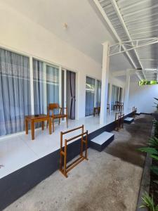 a room with benches and tables and windows at Ina Guesthouse in Lovina +46 photos