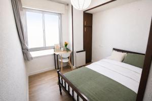 a bedroom with a bed and a desk with a window at Letras del Tormes in Salamanca
