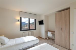 ein Schlafzimmer mit Bett, Schreibtisch und Fenster in der Unterkunft Be1960 Max in Bagá