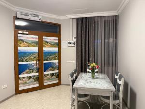 a dining room with a table with a vase of flowers on it at Guest House MD 2 in Tatʼev