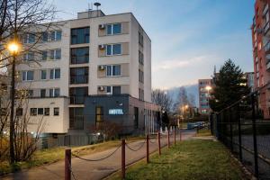a tall white building with a fence in front of it at Afrika Hotel Frýdek-Místek in Frýdek-Místek