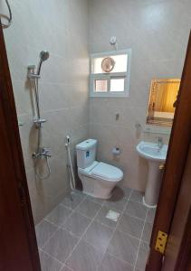 a bathroom with a toilet and a sink at Aknan Al Saada in Salalah +7 photos